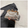 Close-up of silver sequin evening bag with gold metal handle and ball clasp detail - Silver