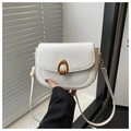 Detail of white leather saddle bag showing elegant gold U-shaped metal buckle and texture - White