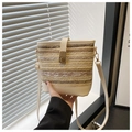 Détail du sac seau en paille tressée avec garniture en cuir crème et fermoir en métal doré - Blanc