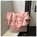 Detalle de bolso tote de tela rosa con elegantes bordes de volantes y textura suave - Rosa