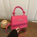 Magenta retro tote bag with golden bow buckle and knotted handle in a lifestyle setting - Rose Pink