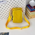 Detail van de gele nylon crossbodytas met trekkoordsluiting en ritsvak aan de voorkant - Geel