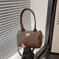 Detalle del bolso Boston marrón con estampado de monograma vintage y cierre de mariposa blanca - Marrón