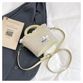 Detail of green straw woven bag with white lace trim, bow knot, and leather handle - Yellow