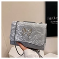 Détail du sac bandoulière argenté texturé avec boucle papillon métallique et chaîne - Argent