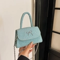 Mini lichtblauwe glitter handtas met zilveren strik en een metalen kettingriem - Cyaan Blauw
