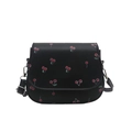 Black leather saddle bag featuring sweet red cherry prints and adjustable shoulder strap - Black