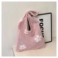 Close-up of pink crochet tote bag featuring white floral patterns and knit texture - Pink