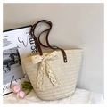 Detalle de un bolso tote tejido beige con lazo de encaje y correas de cuero marrón - Con Colgante de Encaje / Blanco Roto