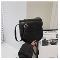 Close-up of black saddle bag with glossy finish, metal buckle, and adjustable strap - Black