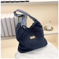 Detailed close-up of blue denim tote bag featuring plaid lining and fashion leather patch - Blue Checkered Side B