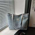 Blue denim tote bag with rhinestones and silver leather handles on white windowsill - Light Blue