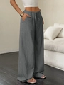Detail of grey wide leg trousers featuring textured fabric and adjustable drawstring waist - Dark Gray