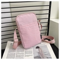 Detailed close-up of pink nylon mini crossbody phone bag with adjustable strap on newspaper - Pink