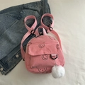 Pink corduroy mini backpack with cute smiley face patterns and a white pompom charm - Pink