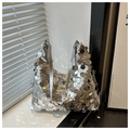 Détail d'un sac hobo à paillettes argentées avec reflets métalliques et bandoulière - Argent