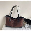 Detail of leopard print tote bag with black leather straps on a white bed with accessories - No Pendant / Brown