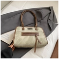Nahaufnahme der Canvas-Handtasche mit braunem Lederbesatz, Metalllogo und Quasten-Detail - Ohne Anhänger / Khaki