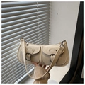 Detail of beige underarm bag with dual pockets, metal buckles and textured PU leather - White