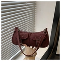 Detail of burgundy faux suede shoulder bag with dual utility buckle pockets and silver hardware - Red