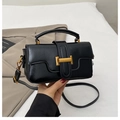 Detalle de bolso en cuero negro brillante con hebilla dorada en H y correa de bandolera - Negro
