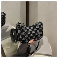 Detail of checkered denim shoulder bag featuring fringe edges and silver chain strap - Black Checkerboard