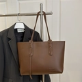 Minimalistische braune Tragetasche mit FASHION-Schriftzug am Kleiderständer - Braun