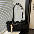 Retro black suede tote bag with wooden bead pendant and long shoulder strap in natural light - Black