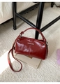 Dettaglio della trama in ecopelle bordeaux vintage e placca metallica con logo sulla borsa - Rosso