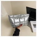 Detailed view of silver quilted clutch bag held by hand next to a laptop - Silver