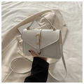 Détail d'un sac à bandoulière en cuir blanc avec boucle dorée et lanière - Blanc