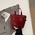 Glanzende bordeauxrode mini emmer tas met goudkleurige noppen en dubbele handgrepen - Bordeauxrood