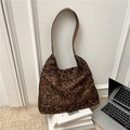 Bolso tote retro con estampado de leopardo y correa de cuero marrón sobre libros - Marrón