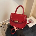 Red leather saddle bag with gold metal clasp and circular handle for women - Red
