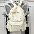 Minimalist beige backpack with black polka dots and mini bow patterns on a grey chair - White Without Pendant