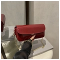 Detailopname van glanzende rode laklederen tas met gouden gesp en elegante kettingriem - Rood