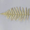Dettaglio di foglia di felce dorata glitterata per decorazioni natalizie e addobbi floreali - Oro