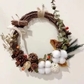 Rustieke kerstkrans met dennenappels katoen en kantstrik aan de witte muur - Eucalyptus Stijl