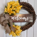 Dettaglio della targa welcome su una ghirlanda di tulipani con fiocco in iuta decorativo - Giallo