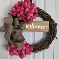 Dettaglio di ghirlanda rustica con tulipani rosa, fiocco di iuta e cartello Welcome - Rosso