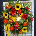 Dettaglio di ghirlanda floreale fatta a mano con girasoli, rose e nastri di pizzo giallo - Peonia Rossa
