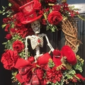 Halloween wreath with white skull, red roses and black berries on a dark wood door - Red