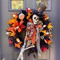 Detail of Halloween wreath with skull, maple leaves and festive ribbons on a wooden door - Multicolor