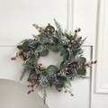 Weihnachtskranz mit Zedernadeln, roten Beeren und Kunstschnee auf weißem Sims - Roter Beeren Kranz