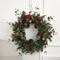 Künstlicher Weihnachtskranz mit Tannennadeln, roten Beeren und Zapfen auf weißem Kamin - Rebe Rote Beere Stil