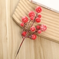 Close-up of frosted artificial red berries with realistic snow on wooden background - Red