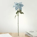 Detail einer hellblauen Poinsettie Kunstblume mit Beflockung auf einem Holztisch - Himmelblau