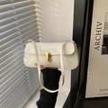 White glossy patent leather baguette bag with a gold metal clasp lock and shoulder strap - White