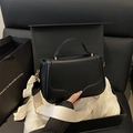 Borsa a mano da donna in pelle nera con base ondulata e tracolla crema - Nero