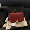 Chic burgundy leather handbag with wavy stitching and wide cream fabric strap - Red